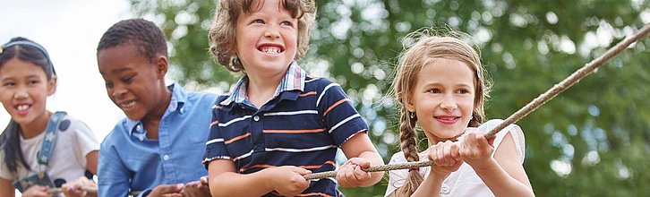 Mehrere Kinder, die an einem Seil ziehen